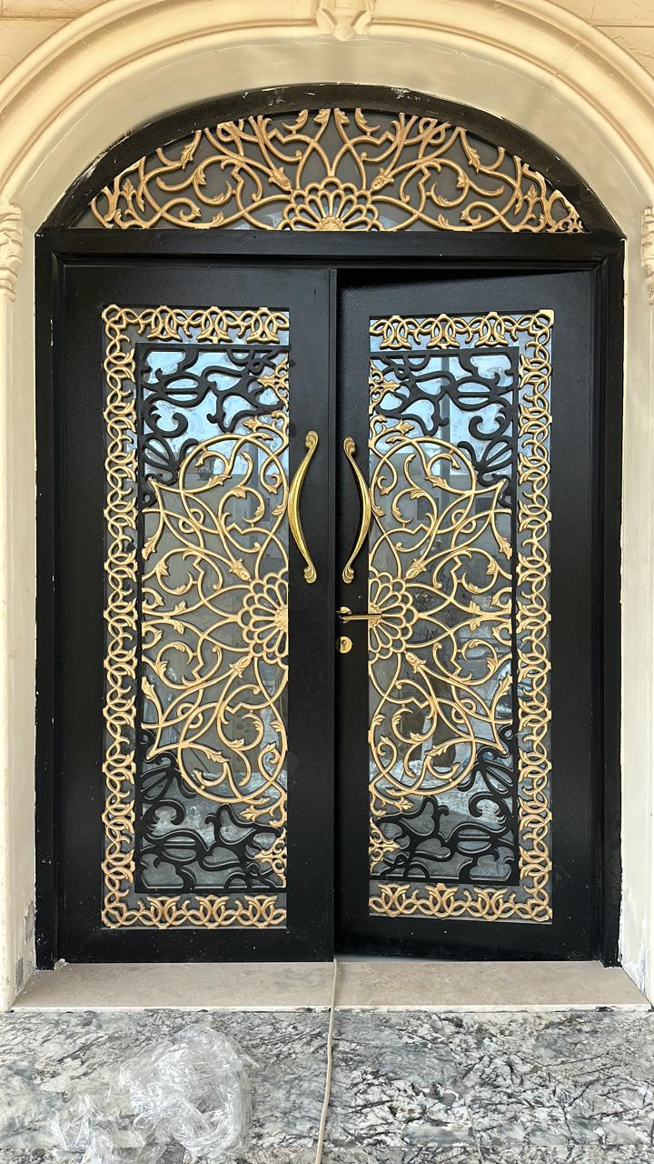 Ornate gold and wrought-iron entrance door at a villa, Abu Dhabi.