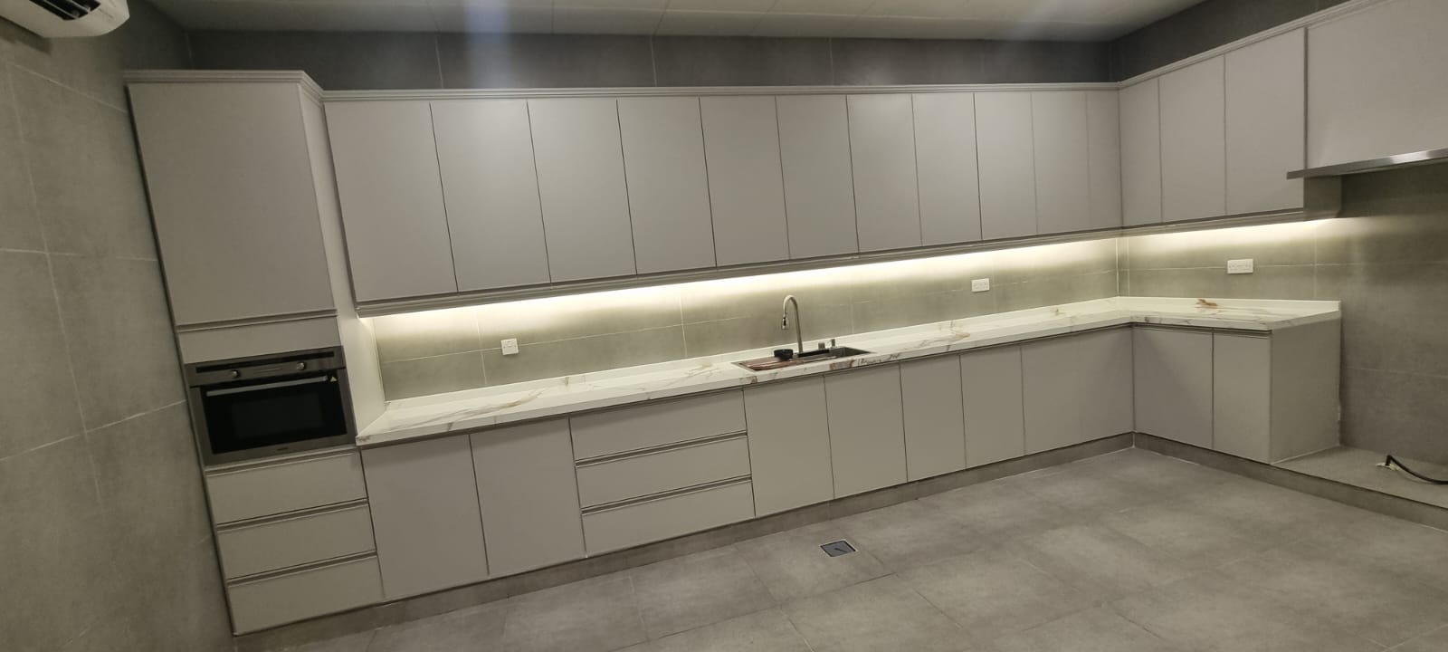 Handle-less kitchen with marble worktops, fitted by Build Marque.