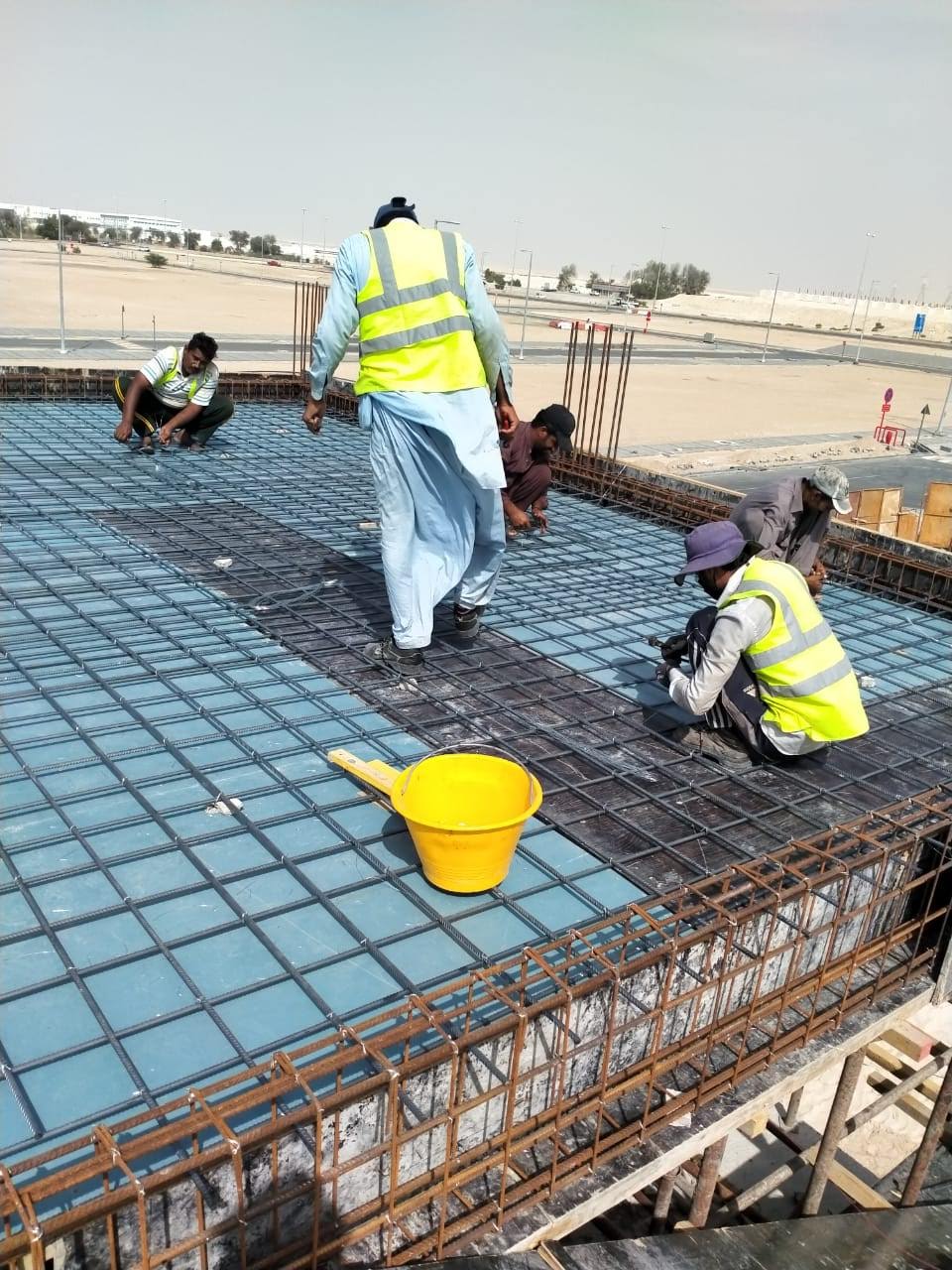 Crew tying first-floor slab reinforcement in Baniyas.