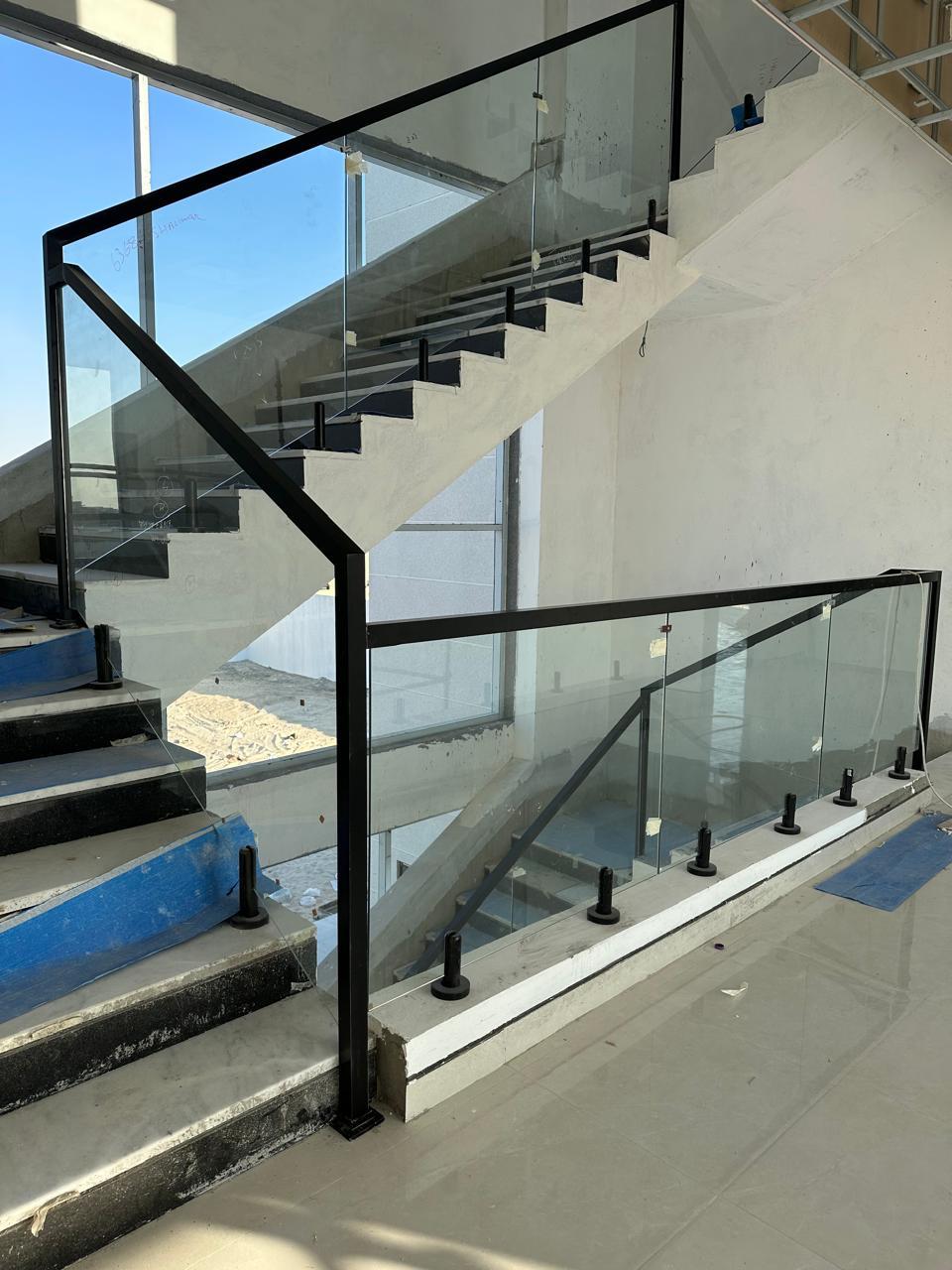 Modern staircase with glass balustrade and black steel frame